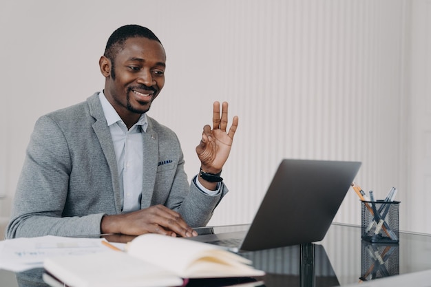 Afrikanischer Lehrer, der online im Home Office arbeitet und Unterricht im E-Learning-Konzept der Gebärdensprache hat