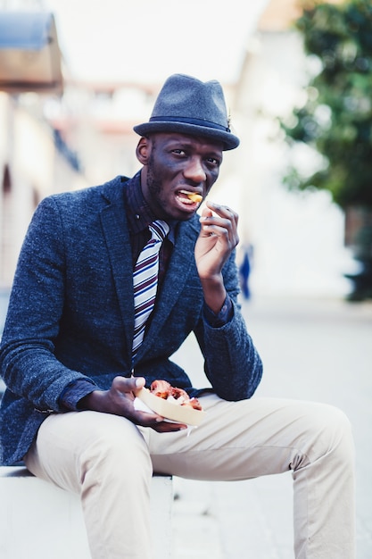 Afrikanischer Mann, der Straßenlebensmittel isst