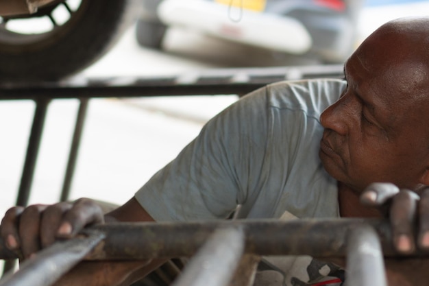 Afrikanischer Mechaniker, der an einem Automotor arbeitet