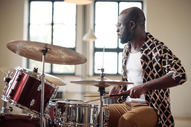 Afrikanischer Schlagzeuger, der am Schlagzeug probt