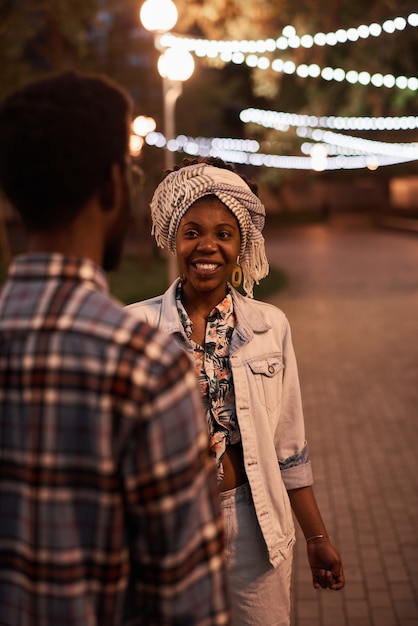 Afrikanisches junges Paar, das abends zusammen im Park spazieren geht