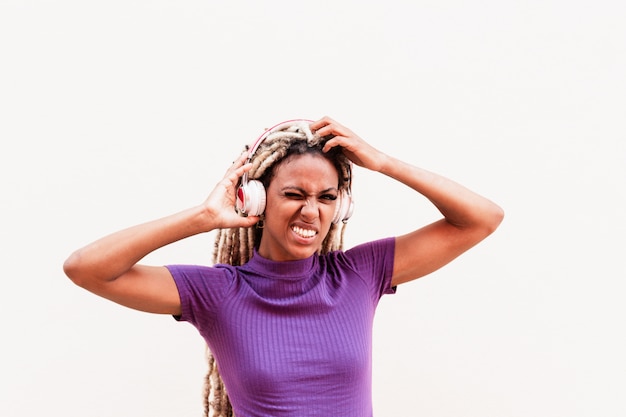 Afrikanisches Mädchen, das blondes Haar der Dreadlocks beim Tragen der Musikwiedergabeliste mit Kopfhörern bewegt