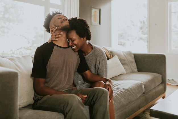 Afrikanisches Paar, das zu Hause in einem Wohnzimmer chillt