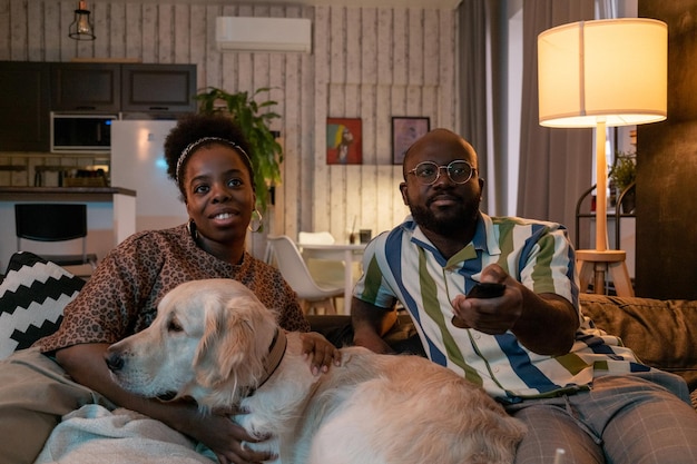 Afrikanisches Paar mit Hund vor dem Fernseher