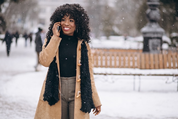 Afro americana mulher com telefone no inverno