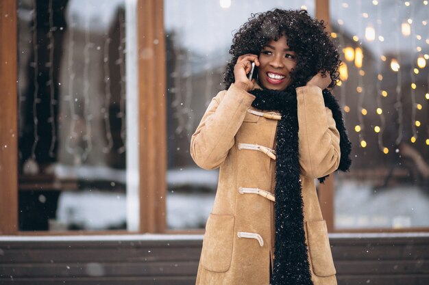 Afro americana mulher com telefone no inverno