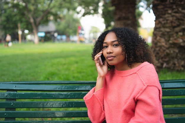 Afro-americana mulher falando ao telefone.