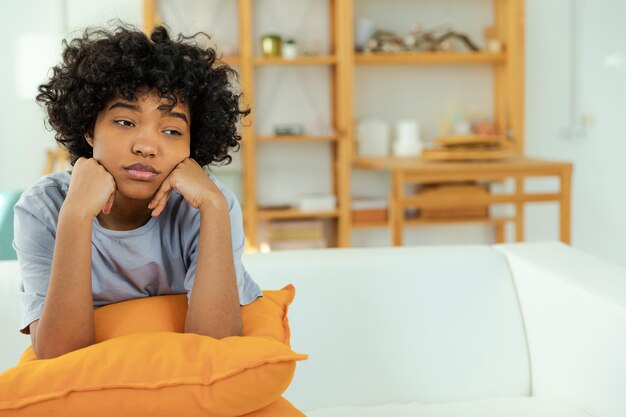 Afro-americana, triste e pensativa, em casa, a jovem africana se sente deprimida, ofendida e solitária