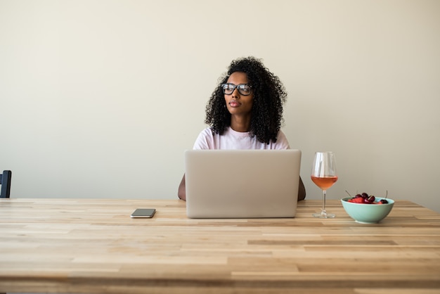 Afro-americano freelancer feminino usando o laptop em casa