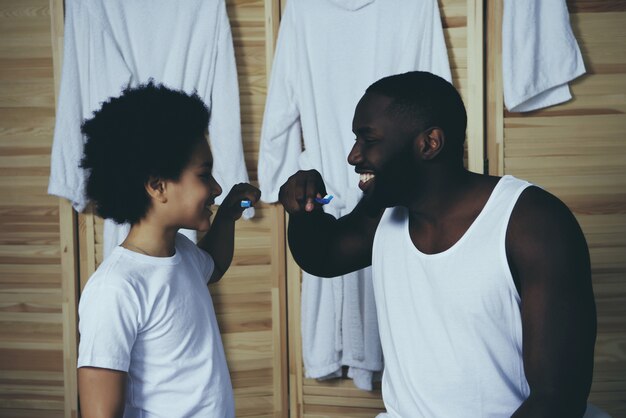 Afro americano pai e filho escovam os dentes