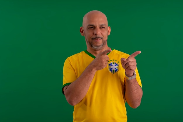 Foto afro brasileiro torcedor da seleção brasileira de futebol na copa de 2022 com a bandeira do brasil e com um rosto facial