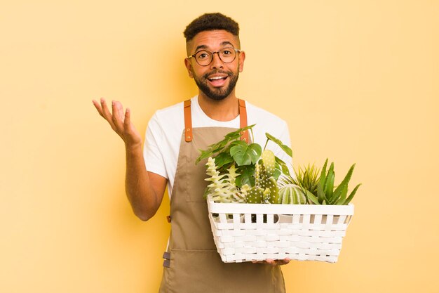 Afro-cooler Mann, der glücklich überrascht ist, eine Lösung oder Idee Gärtner und Pflanzenkonzept zu realisieren