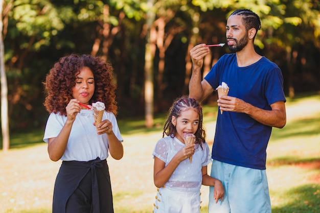 Afro-Familie im Park, die Eis isst