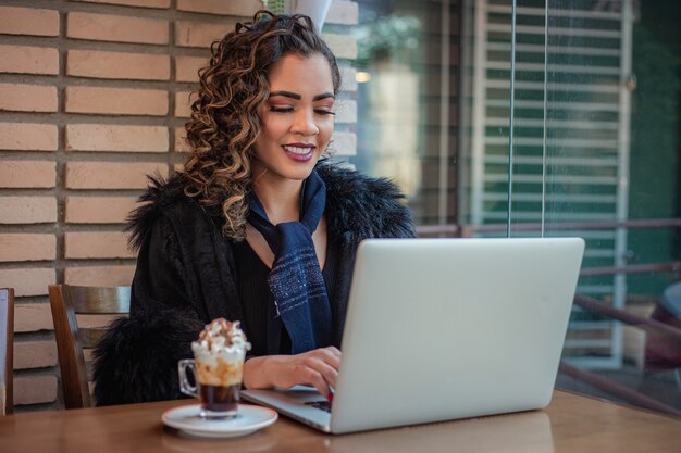 Afro-Frau arbeitet aus der Ferne mit ihrem Laptop.