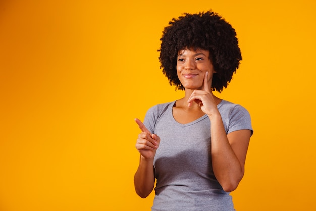 Afro-Frau, die auf Gelb mit Platz für den Text zeigt