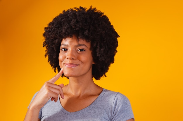 Afro-Frau, die auf Gelb mit Platz für Text denkt