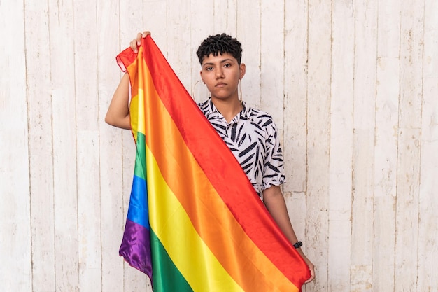 Afro-Frau, die eine Gay-Pride-Flagge zur Unterstützung von Gay Pride auf der Straße hält