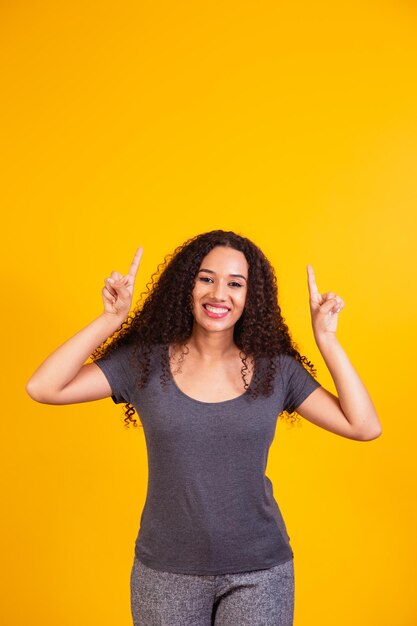 Afro-Frau, die mit freiem Platz für Text nach oben zeigt.