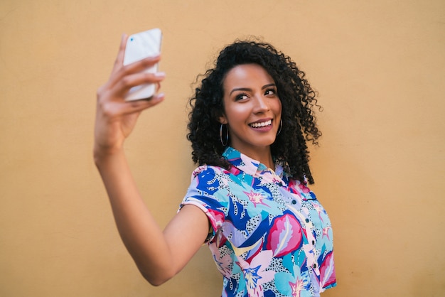 Afro-Frau, die Selfies mit Telefon nimmt.