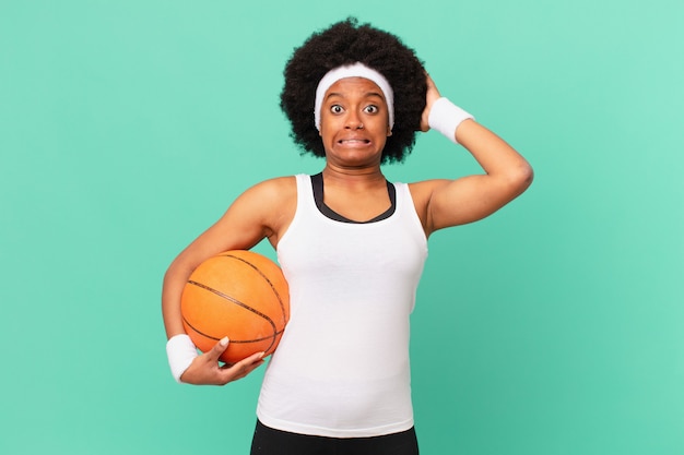 Afro-Frau, die sich gestresst, besorgt, ängstlich oder ängstlich fühlt, mit den Händen auf dem Kopf, bei Fehlern in Panik geraten. Basketball-Konzept