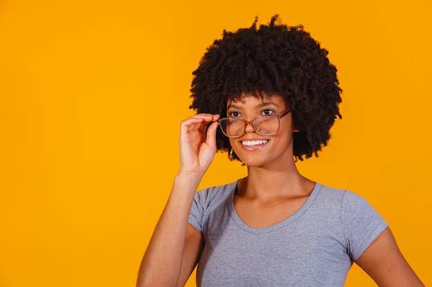 Afro-Frau mit Brille, die in die Kamera lächelt