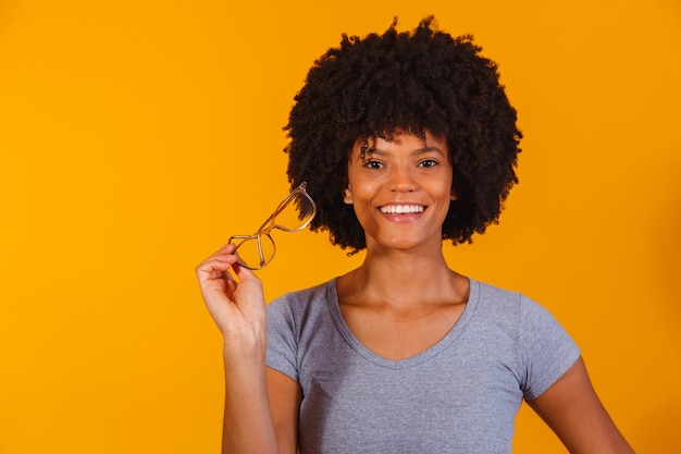 Afro-Frau mit Brille, die in die Kamera lächelt