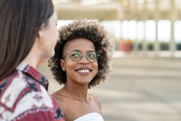 Afro-Frau mit Brille sieht lächelnd ihren weißen Freund an