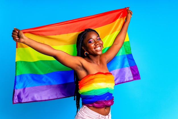 Afro-Frau mit LGBT-Stolzflagge im blauen Studiohintergrund