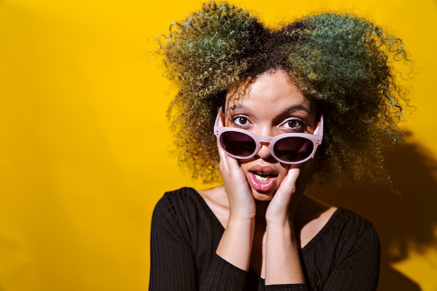 Foto afro-frau überrascht auf gelbem hintergrund