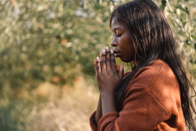 Afro Girl mit geschlossenen Augen, im Freien betend