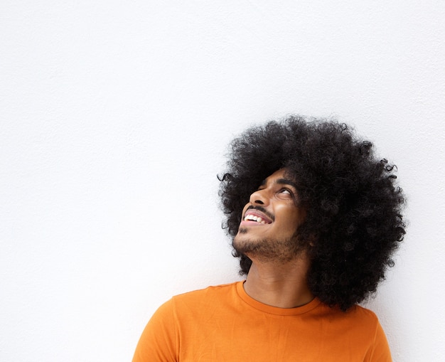 Afro hombre sonriendo y mirando hacia arriba