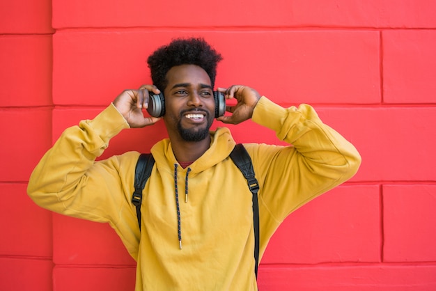 Afro jovem ouvindo música com fones de ouvido.