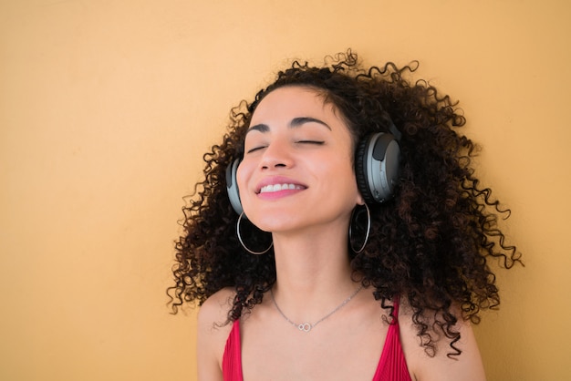 Afro jovem ouvindo música com fones de ouvido.