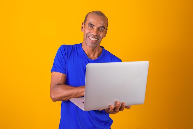 Afro-Mann, der online per Computer einkauft oder arbeitet