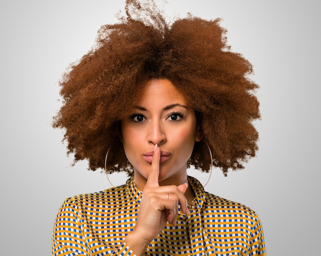 Afro mujer haciendo un signo de silencio