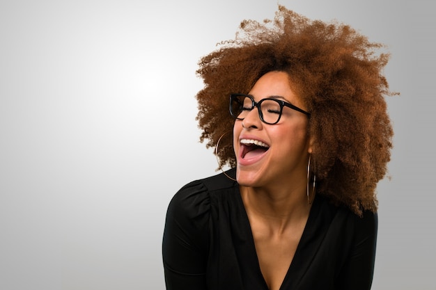 Afro mujer riendo feliz llevando gafas