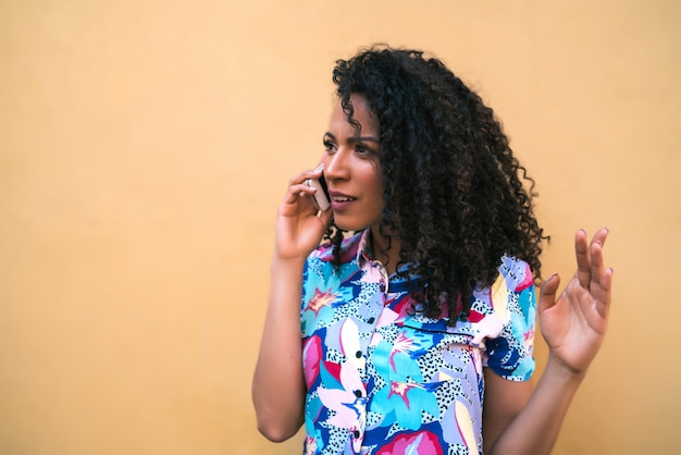 Afro mulher falando ao telefone.