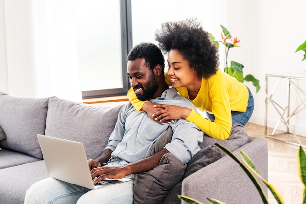 Afro-Paar, das zu Hause einen Laptop benutzt