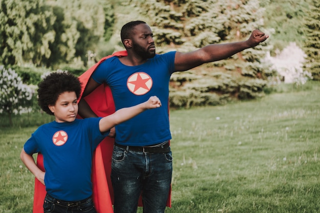 Afro-Sohn und Vater tragen Anzüge von Superhelden.