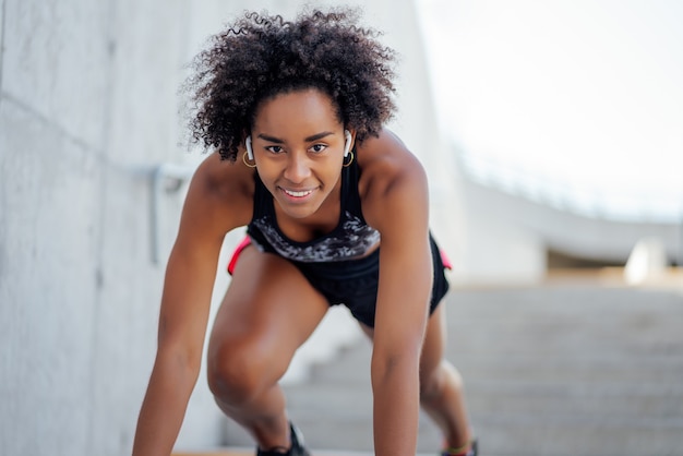 Afro sportliche Frau bereit, im Freien zu laufen. Sport und gesunder Lebensstil.