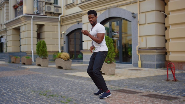 Afro-Typ tanzt Latino-Tanz auf der Straße Männlicher Tänzer, der Körperbewegungen in der Stadt macht