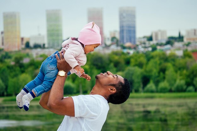 Afro-Vater umarmt ihre Mischlingstochter und verbringt Zeit im Garten