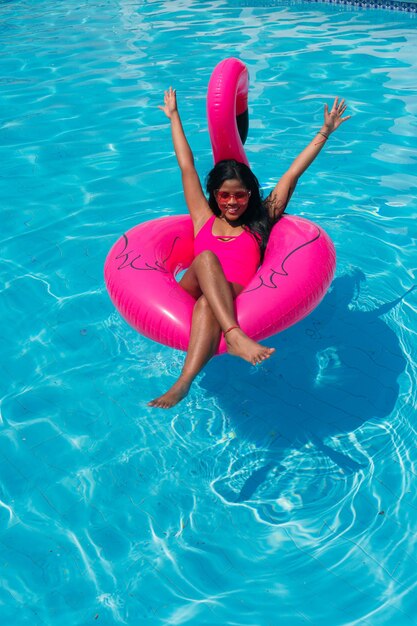 Afroamericana en la piscina relajándose en un inflable