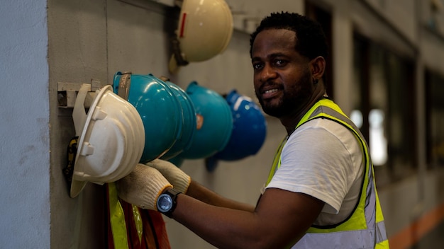 Afroamericano con casco de seguridad Equipo de casco de seguridad en el sitio de la fábrica de fabricación