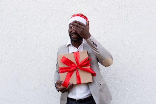 El afroamericano en gorra de año nuevo con un regalo