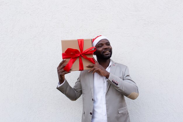 El afroamericano en gorra de año nuevo con un regalo