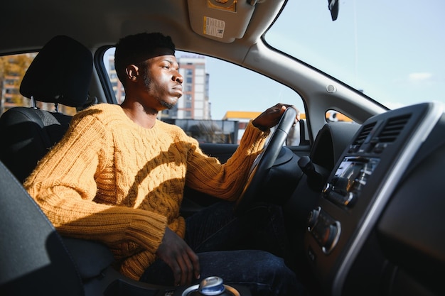 Afroamerikaner, der ein Elektroauto fährt.