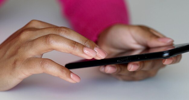Afroamerikaner, der ein taktiles mobiles Smartphone hält - schwarze Menschen.