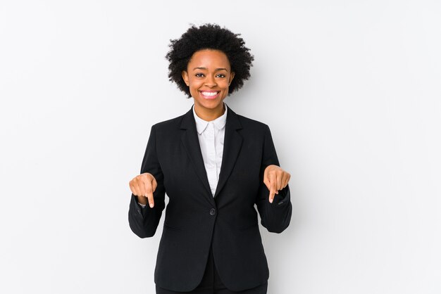 Afroamerikaner-Geschäftsfrau mittleren Alters gegen eine weiße Wand lokalisierte Punkte unten mit den Fingern, positives Gefühl.