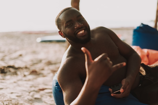 Afroamerikaner-Kerl legt auf Osmanen.